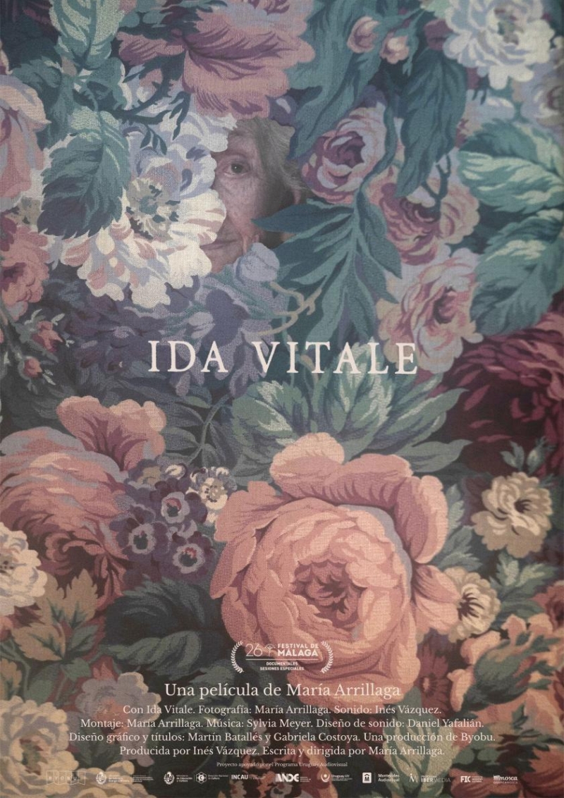 Poster de la película documental Ida Vitale, detrás rodeada de flores y hoja aparece el rostro a medias de una mujer mayor.